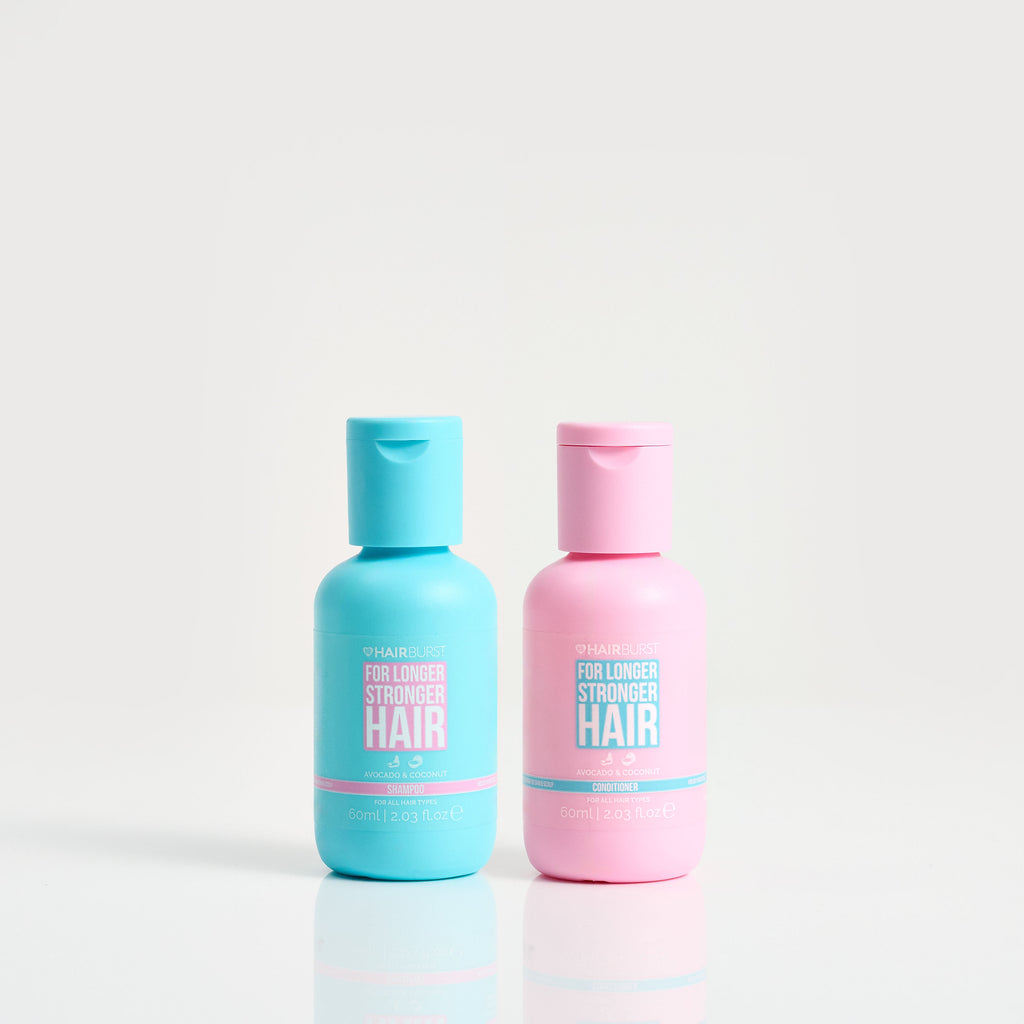 Two bottles of hair care product, one blue and one pink, on a white background.